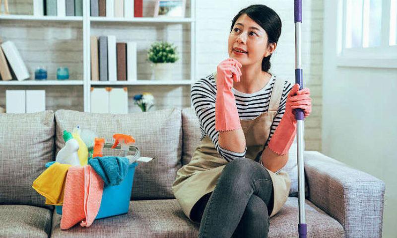Hình ảnh người đang nằm dài, xung quanh bừa bộn, thể hiện sự lười biếng thiếu động lực, minh họa tính từ chỉ tính cách tiêu cực