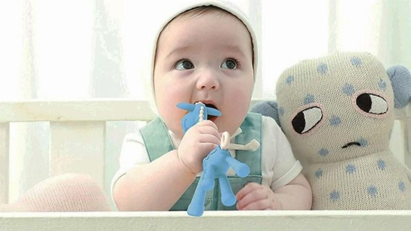 Bé đang cho tay hoặc đồ vật vào miệng gặm, dấu hiệu phổ biến của sự ngứa nướu khi mọc răng