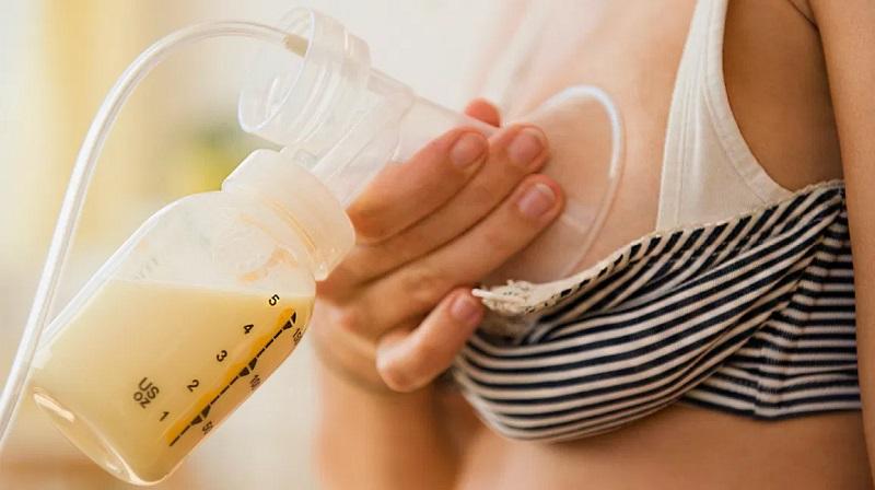 Hình ảnh người mẹ đang băn khoăn, lo lắng về việc cho bé uống sữa mẹ hâm lại